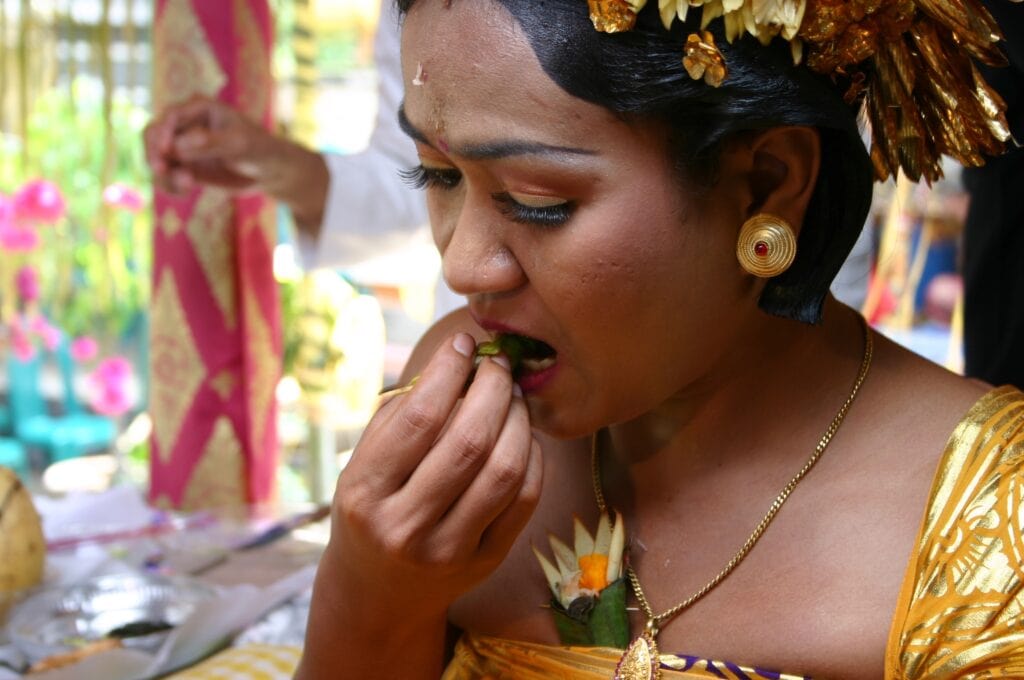 Portrait of Balinese Woman test teeth bites after ceremony of 