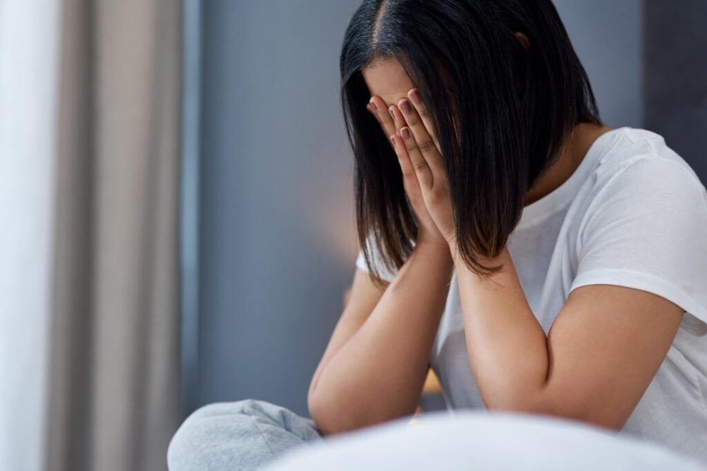 Stress, crying and sad woman in bedroom, tired and expression for mental health, lonely and emotion. Reaction, exhausted or person with depression, sick and fatigue with grief or panic attack in home