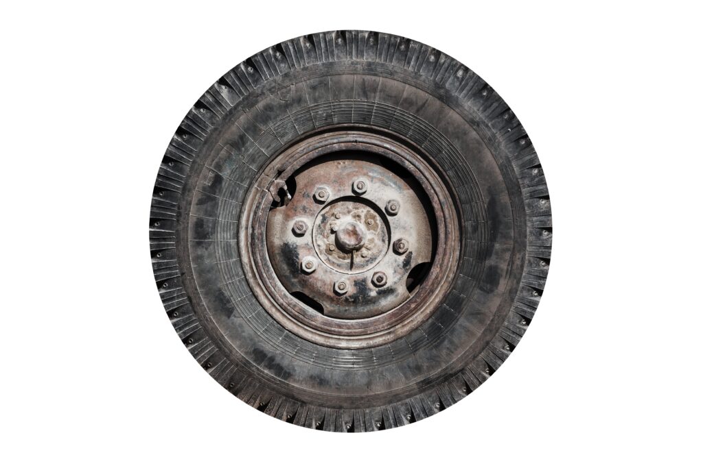 Old rusty truck wheel isolated on white background, front view