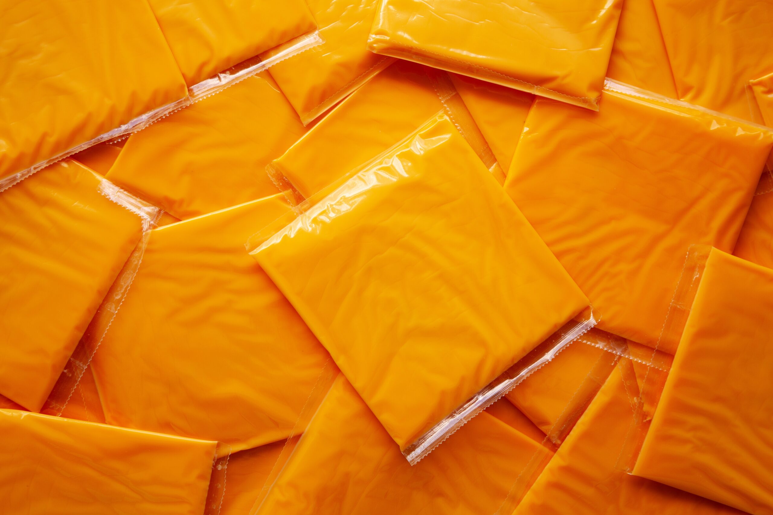 American Cheese Slices in Wrappers, top view. Flat lay, overhead.