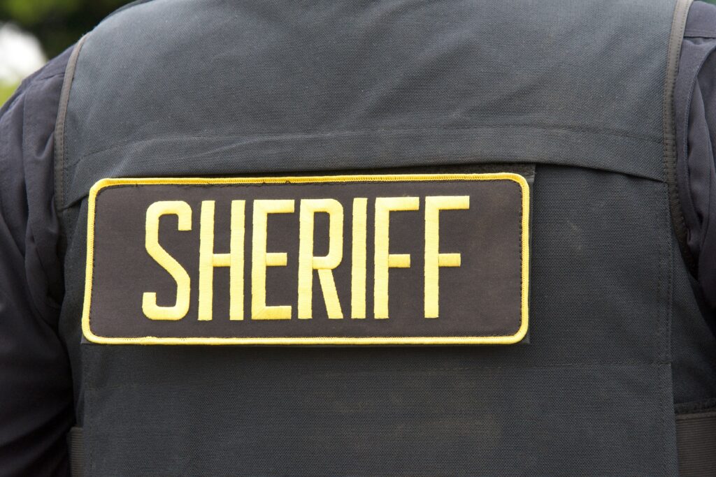 Close up on Sheriff letters on back of flack jacket.