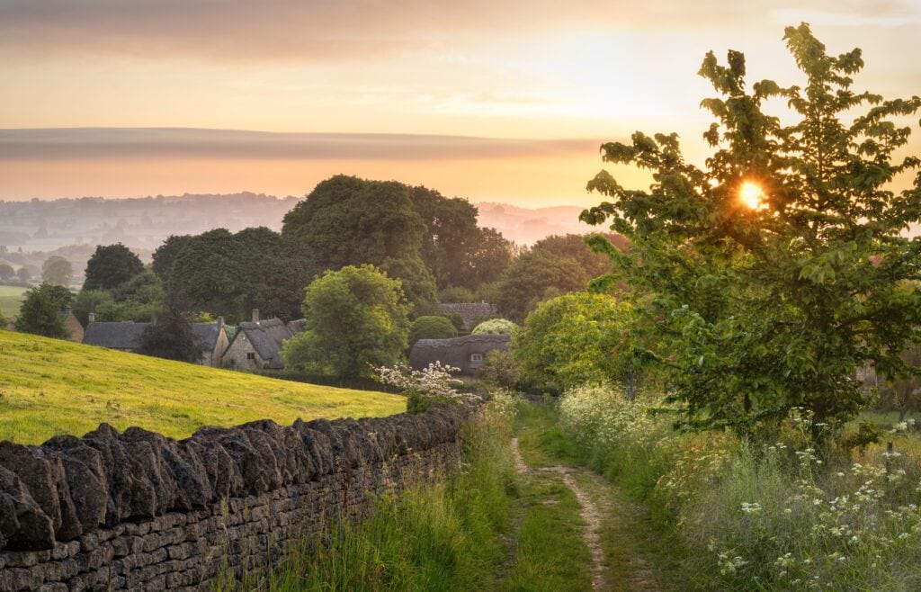 View down a country track towards thatched cottages at Broad Campden, Cotswolds, England