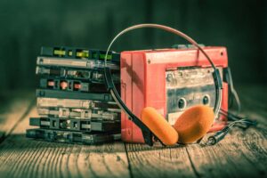 Closeup of cassette tape, red walkman and headphones