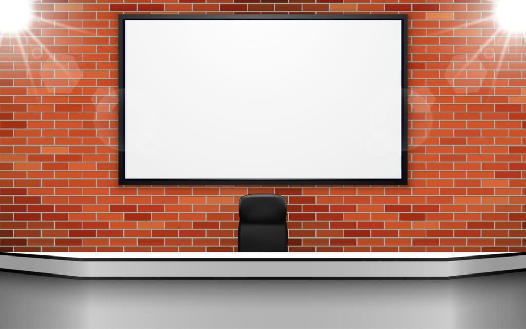 white table with lcd on the brick wall in the news studio room