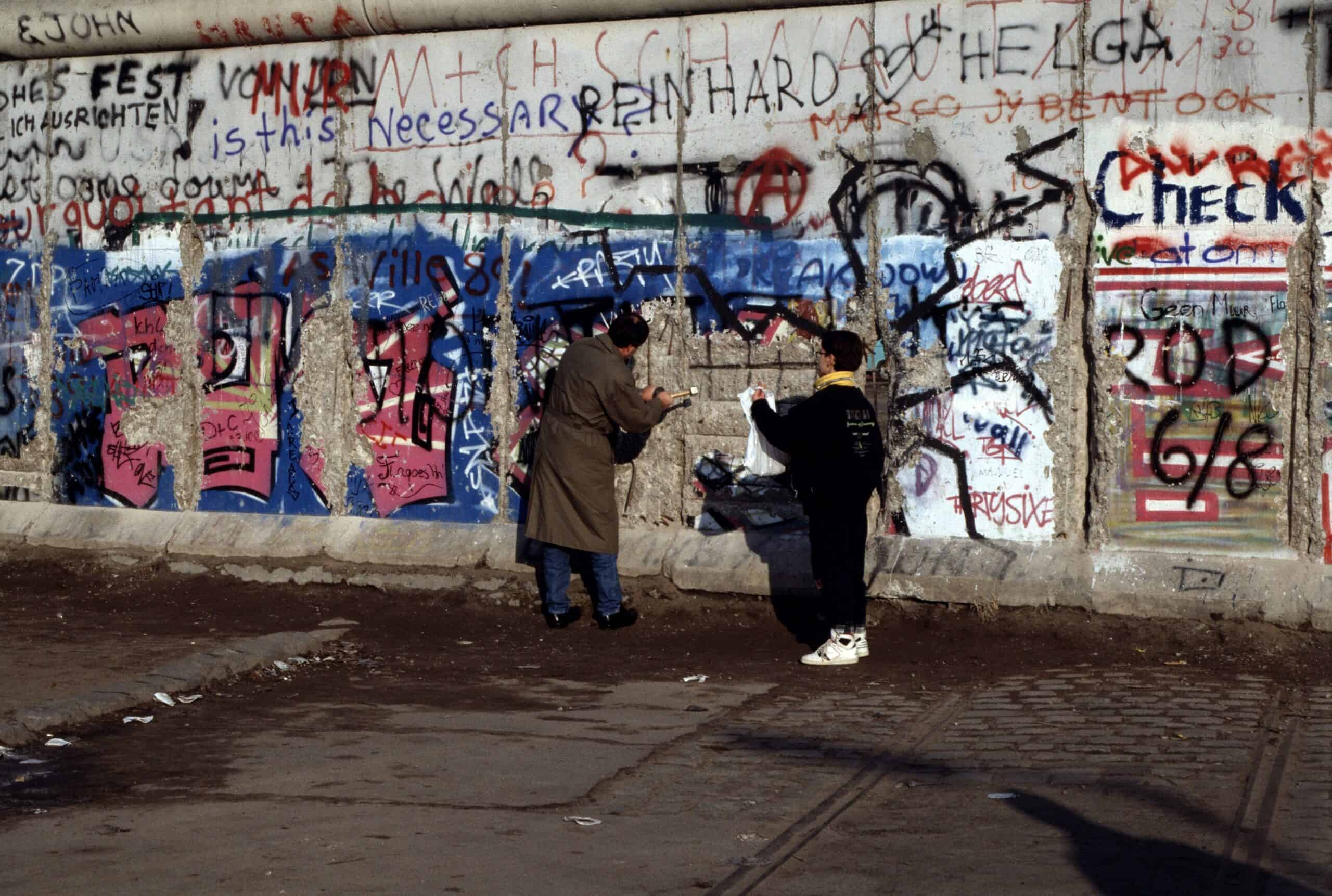 People chipping away at the Berlin Wall on December 1, 1989, following the opening of the border