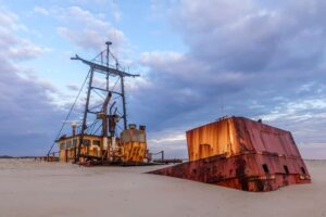 Rustic shipwreck being swallowed up by the sand