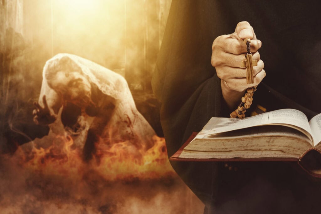 Close up of exorcist hands holding a cross and bible while expelling ghost bride and burning her