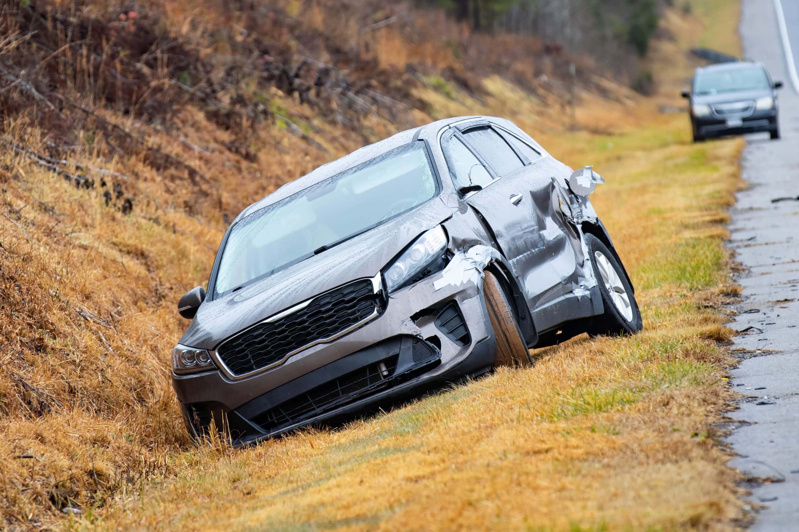 Crashed car in ditch o the side of highway nobody at day