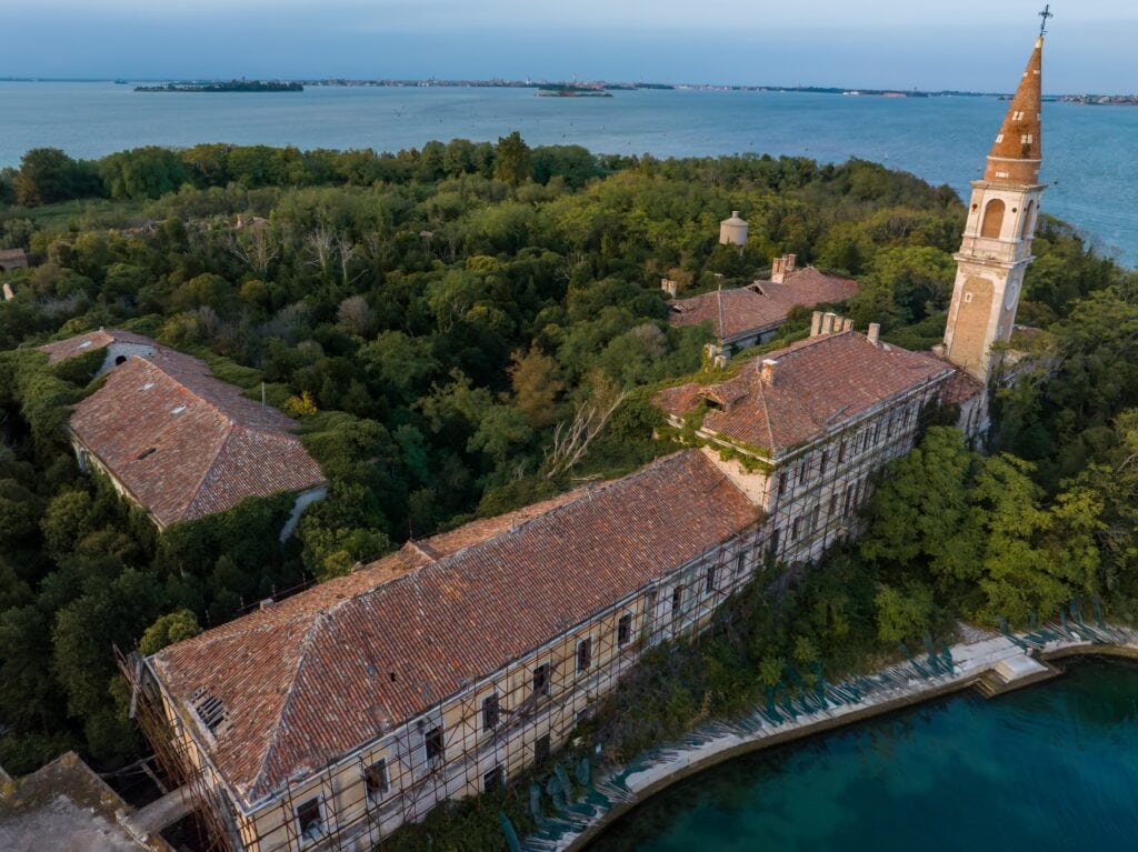 Aerial view of the plagued ghost island of Poveglia in the Venetian lagoon, opposite Malamocco along the Canal Orfano near Venice, Italy.