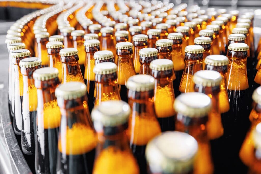 Brewery conveyor on modern alcohol drink production line. Brown glass beer bottles on industry plant
