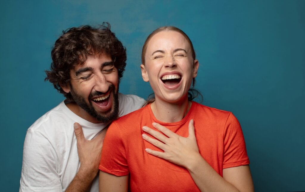 laughing out loud at some hilarious joke, feeling happy and cheerful, having fun