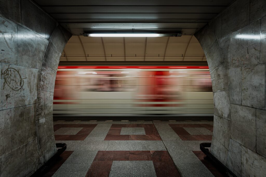 Train passing in a brutalistic subway station. Ultra wide shot with moving train.